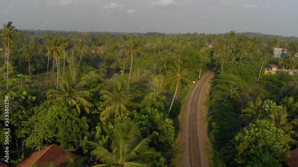 Railroad curving into the exotic forest of Sri Lanka, beautiful drone shot over the village of Midigama, 4k 24fps. Railroad curving into the exotic forest of Sri Lanka, beautiful drone shot over the village of Midigama, 4k 24fps.