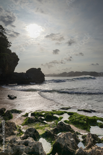 Sunset view with sea wave foam at Batu Bengkung Beach. Exotic paradise in Malang, East Java, Indonesia. Scenic ocean wave view of beach. photo