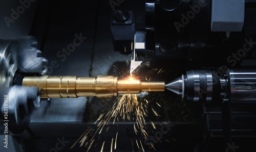 Metal machine tools industry. CNC turning machine high-speed cutting is operation.flying sparks of metalworking photo