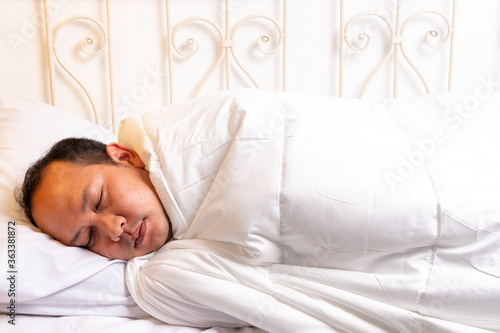 Handsome asian Man sleeping in white bedding