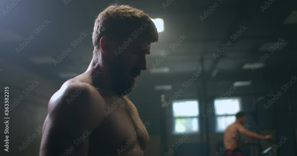Time to rest. Young athletic man in sportswear looking exhausted while standing in front of windows at gym. Time to rest. Young athletic man in sportswear looking exhausted while standing in front of windows at gym.