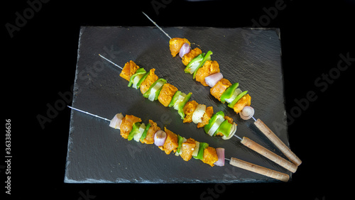 Trio of turkey skewers with curry, on a slate
