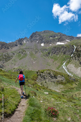 girl practicing mountain hiking in spring with a small river in the background in the Pyrenees