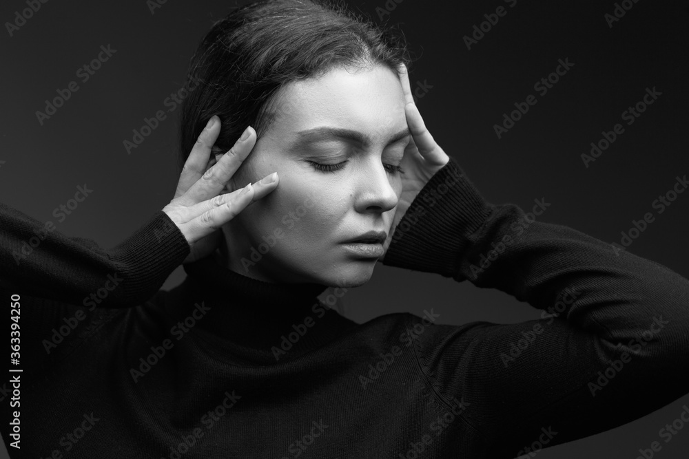 Attractive brunette girl in a dark sweater poses for the camera. black and white image Attractive brunette girl in a dark sweater poses for the camera. black and white image