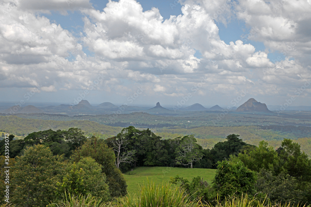 Fototapeta premium Glass House Mountains, Sunshine Coast, Queensland, Australia showing blue sky, mountains, paddocks, farming land and forests