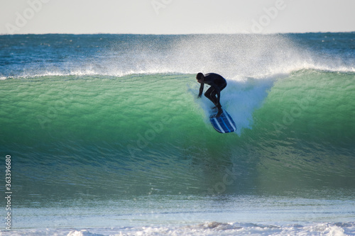 Surfer on Blue Ocean Wave riding on surfing board in Asia. Japan is famous for its great waves near to Tokyo City