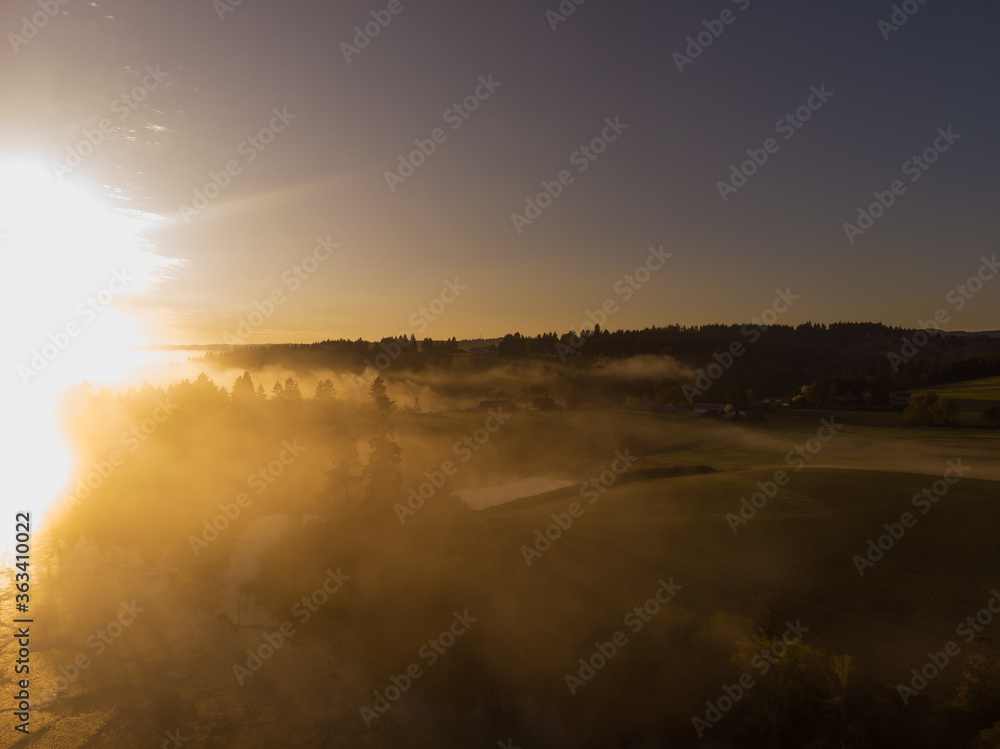 Fototapeta premium Sunset or dawn on a morning lake or swamp, steam and haze