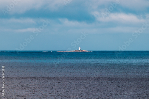 beautiful Tasmanian beach landscape with he Iron Pot island and lighthouse in the distance