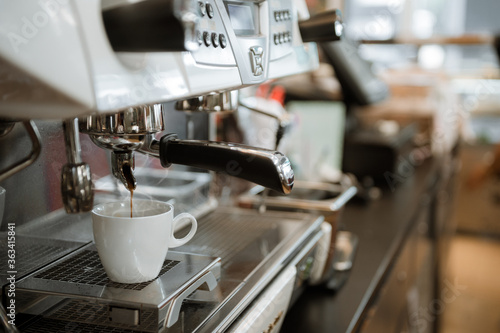 black coffee in white cup put on coffee maker