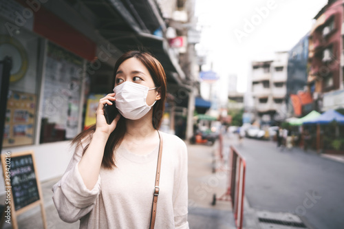 Casual business young asian single woman wear mask for new normal lifestyle in city