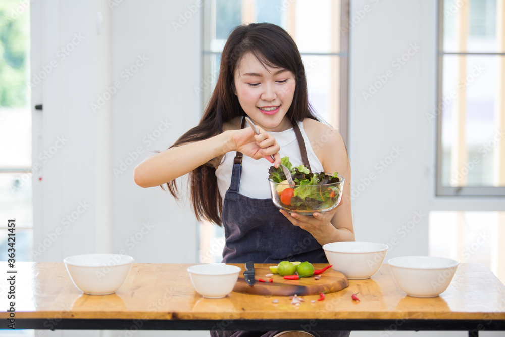 Beautiful Asian women, beautiful smile, good health, beautiful teeth, eating salad vegetable when working at home. Beautiful Asian women, beautiful smile, good health, beautiful teeth, eating salad vegetable when working at home.