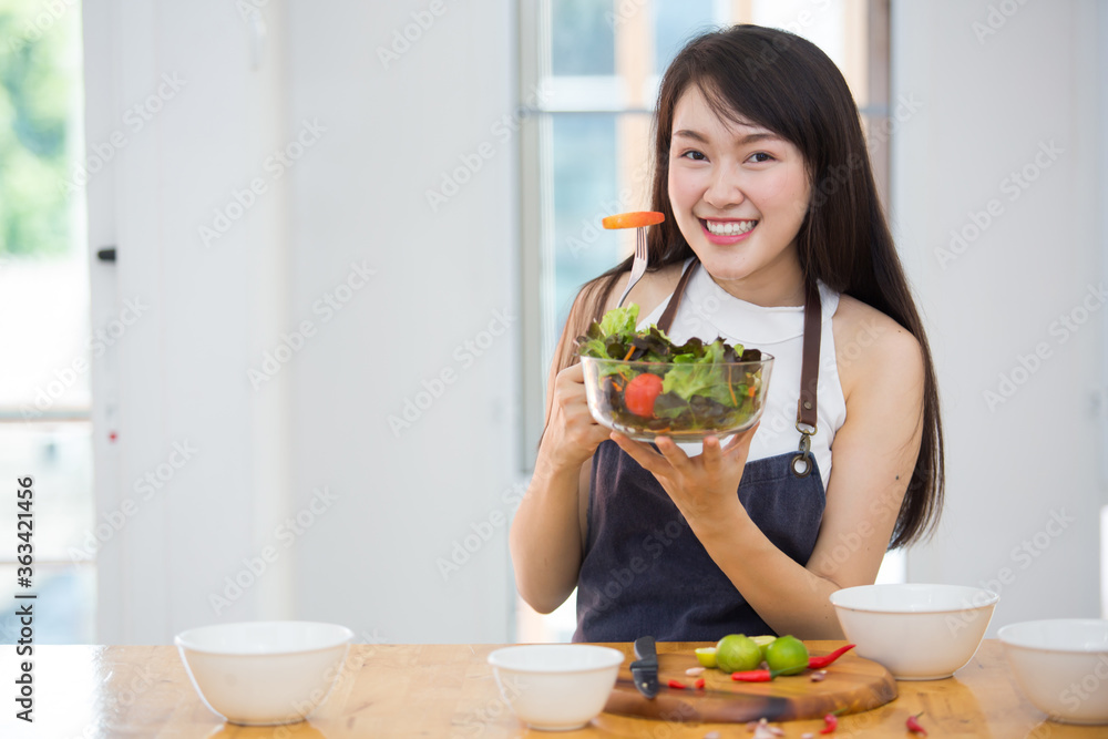 Beautiful Asian women, beautiful smile, good health, beautiful teeth, eating salad vegetable when working at home. Beautiful Asian women, beautiful smile, good health, beautiful teeth, eating salad vegetable when working at home.