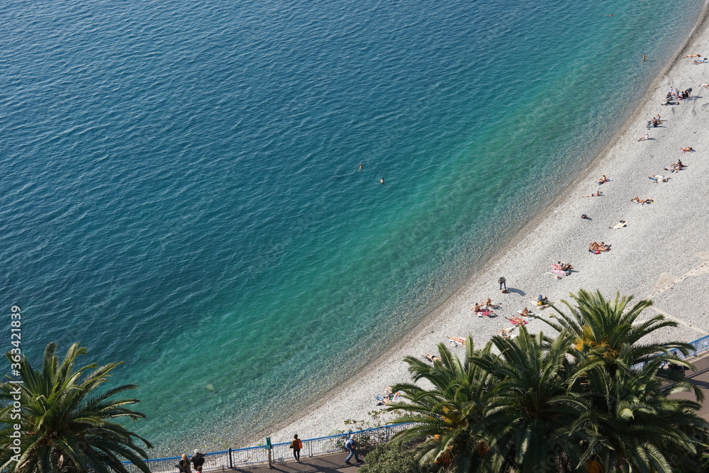 Aerial view of beach in Nice France with turquoise water palm trees and blue sky. Photo for art decoration and blog story.