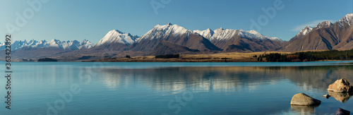 The beautiful still waters of Lake Tekapo reflecting the snow capped Southern Alps in New Zealand