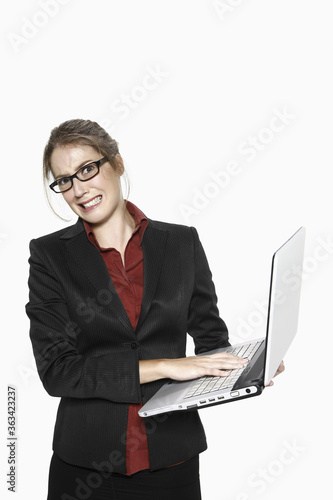 Woman grimacing while using laptop