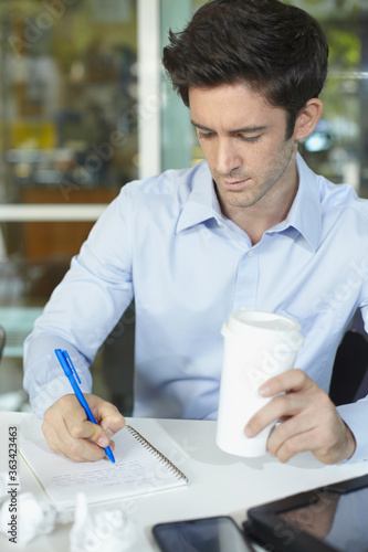 Businessman writing in notebook