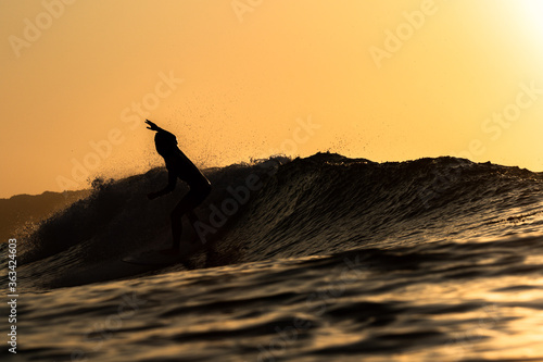 Surfing at sunrise & sunset in Japan Silhouettes of the Surfers taken while swimming in the Pacific Ocean.  photo