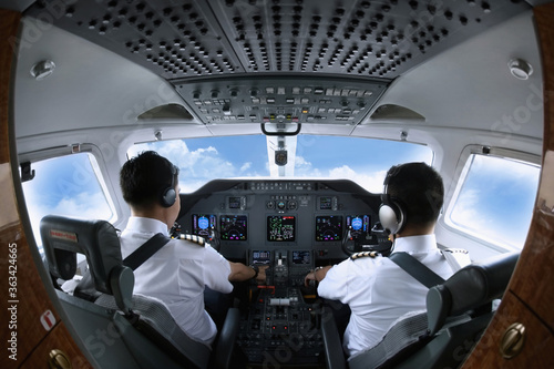 Pilot and co-pilot in private jet cockpit