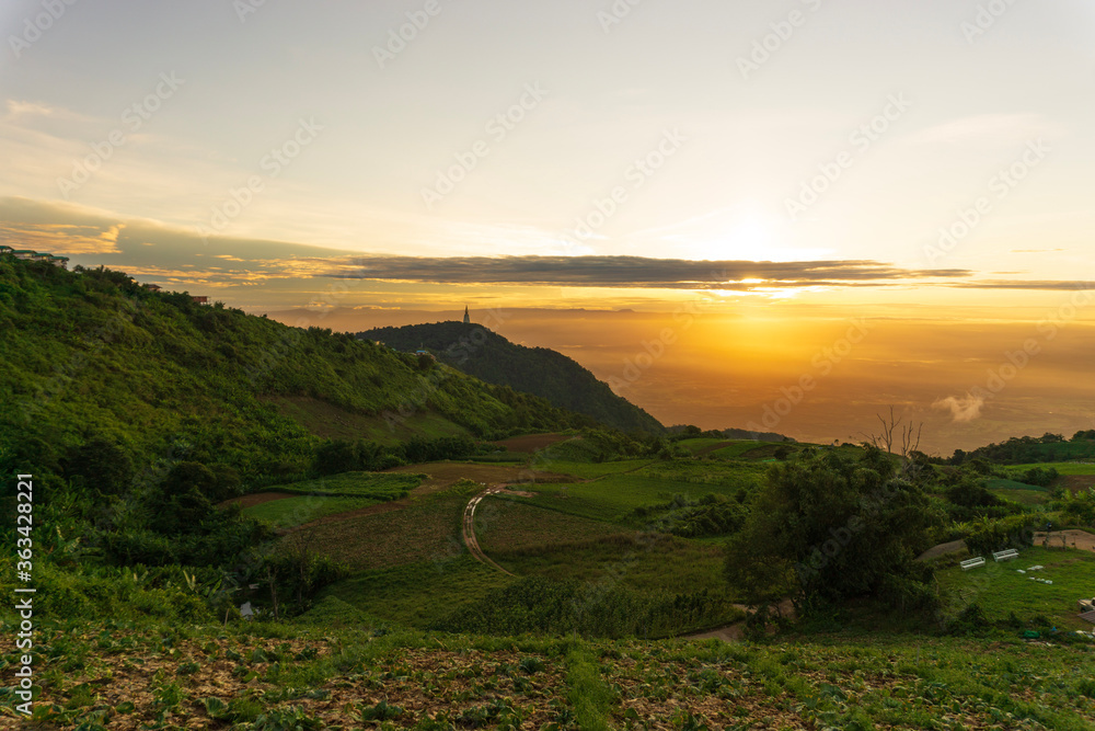 View of landscape with light sunrise on the horizon in the valley. Bright sky over mist mountains. Concept of nature. Tourist attraction Phu Thap Berk, Phetchabun, Thailand