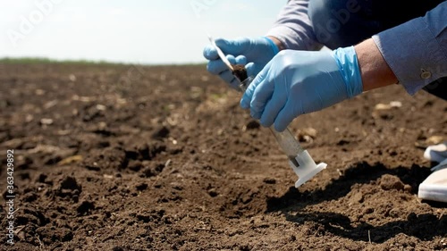 Scientist studying sample of soil in field, closeup photo