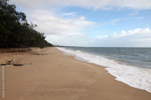 Beautiful Woodgate Beach, Queensland, Australia. Pristine beaches and beautiful weather. Waves, shore, sand and foliage