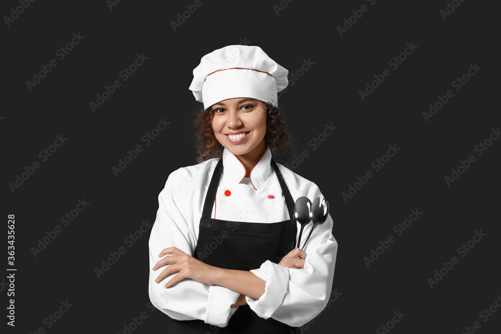 Female African-American chef on dark background Female African-American chef on dark background