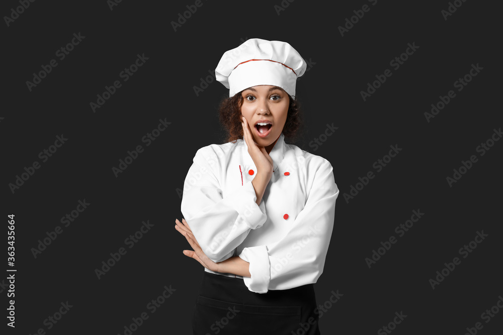 Surprised African-American chef on dark background Surprised African-American chef on dark background