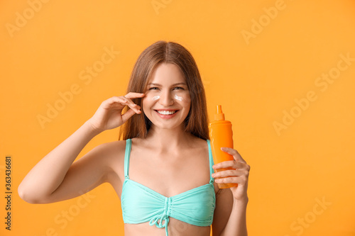 Young woman applying sunscr...