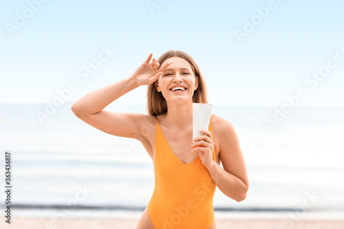 Young woman applying sunscr...