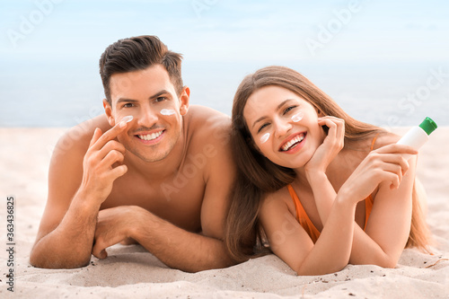 Young couple applying sunsc...