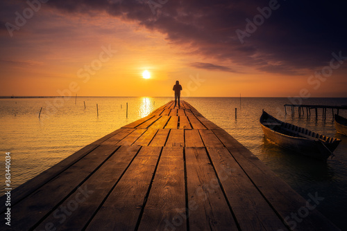 Lonely person standing on a pontoon meditating