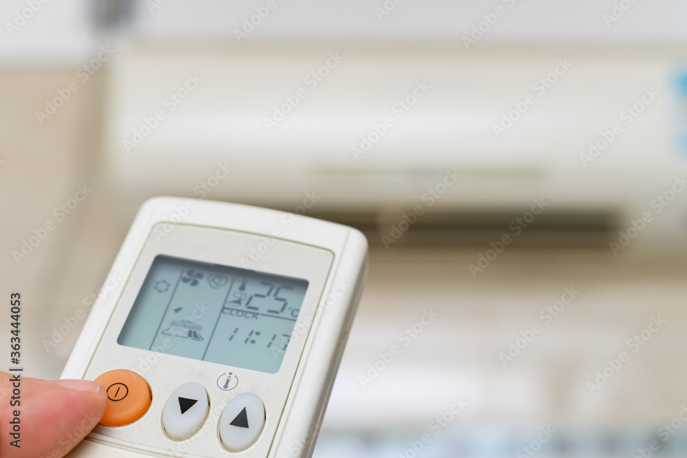 turning on an air conditioner via a remote control turning on an air conditioner via a remote control