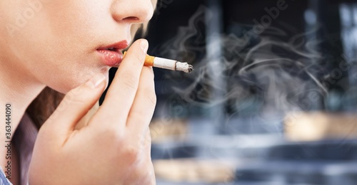 Beautiful elegant young girl smoking a cigarette