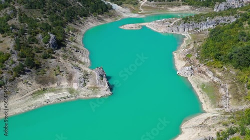 Zeleno jezero reservoir lake in Croatia with exposed shore due to low water level, Aerial dolly out shot photo