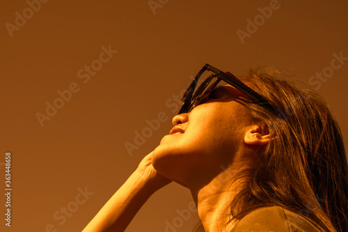 Woman is looking on solar eclipse through three sunglasses. Sun eclipse concept.