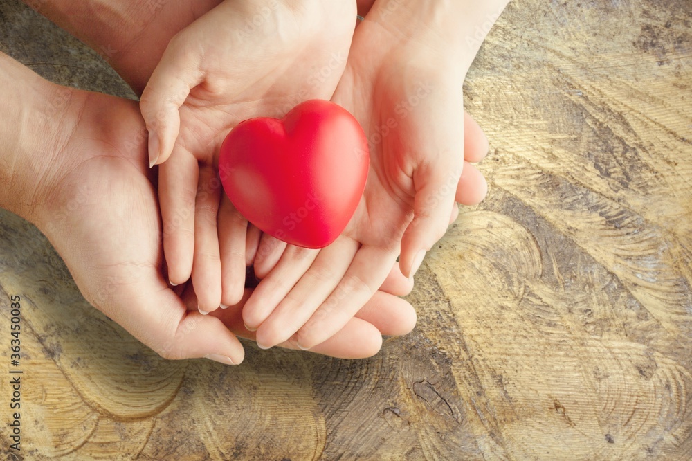 Man and woman holding red heart on background Man and woman holding red heart on background