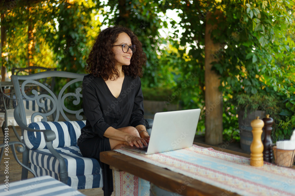 Portrait Of Beautiful Smiling Woman Typing On Notebook Keyboard While Working Online Using Laptop Computer. Female Sitting On Terrace Balcony. Business People. Portrait Of Beautiful Smiling Woman Typing On Notebook Keyboard While Working Online Using Laptop Computer. Female Sitting On Terrace Balcony. Business People.