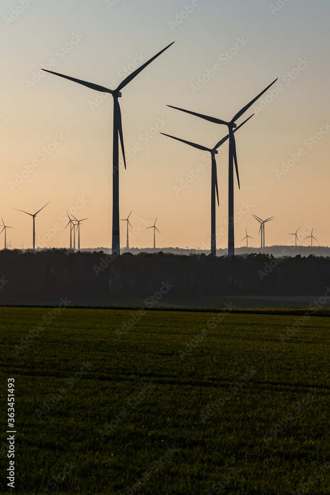 Black Silhouette of windturbines energy generator on amazing sunset at a wind farm in germany Black Silhouette of windturbines energy generator on amazing sunset at a wind farm in germany