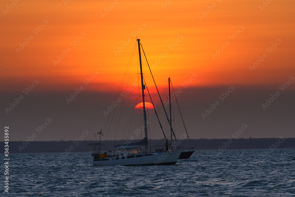 Sailing boats on the sea at sunset. Mindil Beach - Darwin, NT, Australia.