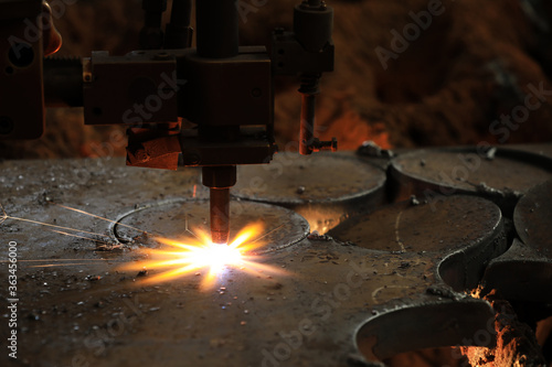 Cnc plasma cutting. Plasma cutters use a number of methods to start the arc. The arc is created by putting the torch in contact with the work piece. photo