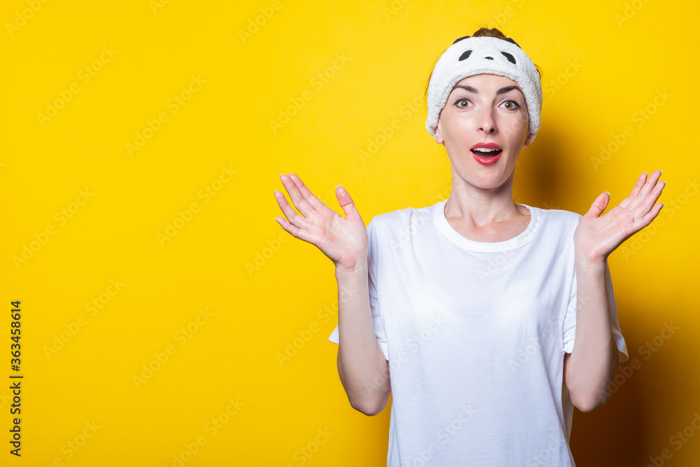 Young woman surprised in shock, spreads her palms to the side on a yellow background. Young woman surprised in shock, spreads her palms to the side on a yellow background.