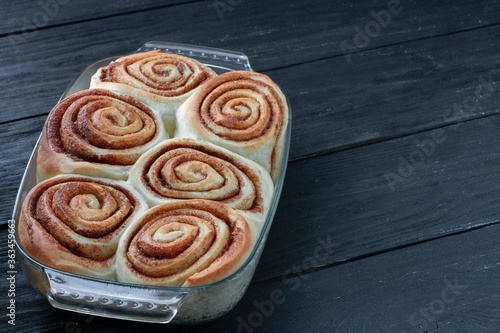 rolls or cinnabon, homemade sweet dessert buns on white baking dish. Top view. Delicious pastries