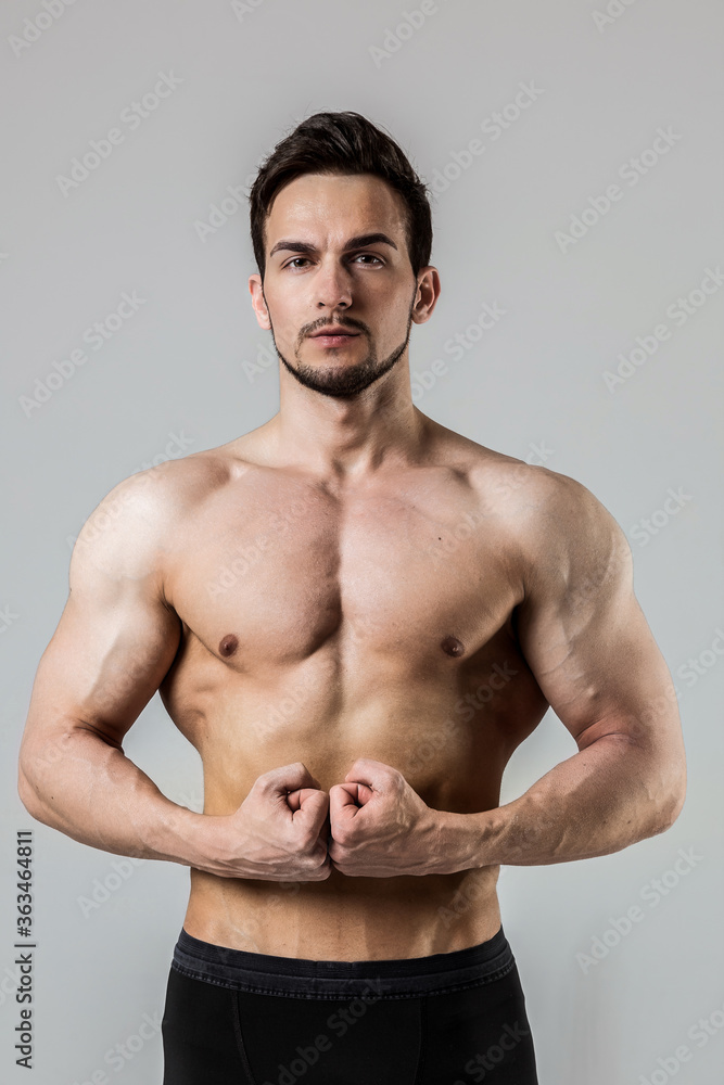 Attractive sporty man with a naked torsoon a white background Attractive sporty man with a naked torsoon a white background