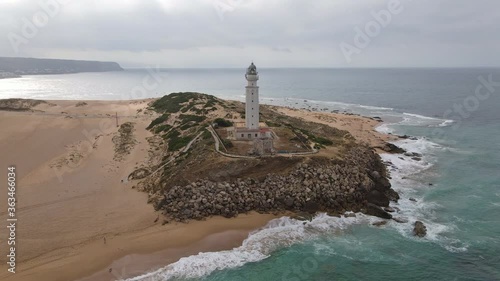 The famous Trafalgar lighthouse with sun in the back light. It is the end of June. The drone flies a quarter circle. Cape Trafalgar can be seen in the background.