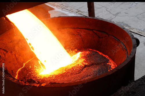 The hot slag of the copper is pouring to the large melting pot. photo