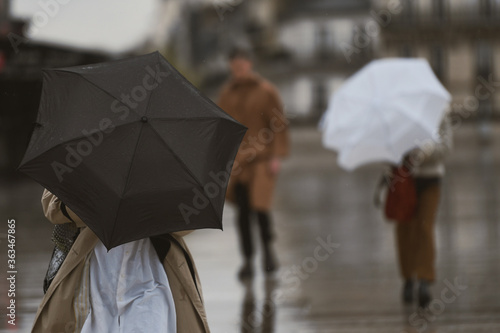 Fototapeta Naklejka Na Ścianę i Meble -  People with an umbrella in a rainy day in Paris