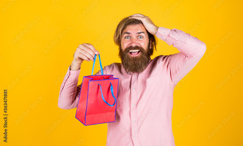 Real happiness. surprised male open shopping bag with something exciting inside. mature man looking casual in surprise with present package. commonly used for birthday. buy anniversary gifts Real happiness. surprised male open shopping bag with something exciting inside. mature man looking casual in surprise with present package. commonly used for birthday. buy anniversary gifts