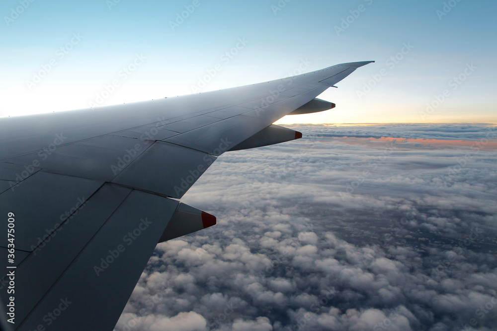 Obraz premium Cloud texture and blue sky with wing during sunrise viewed from airplane