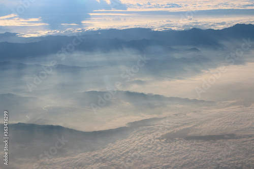 View of earth with the mountain and sea during sunrise from airplane