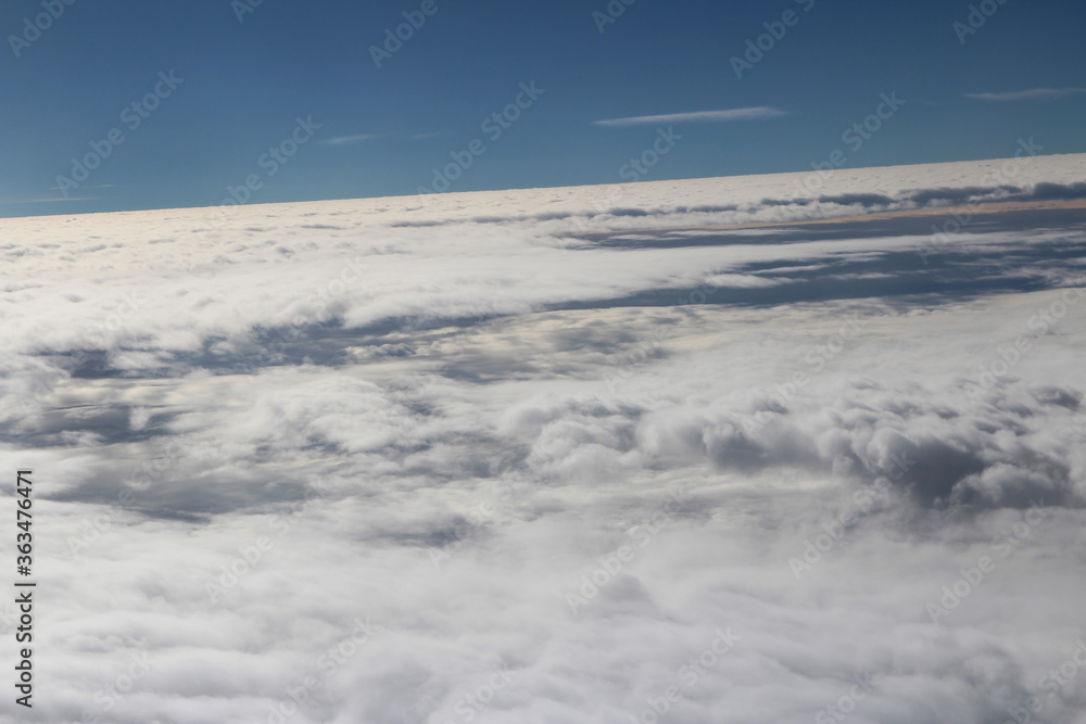 Cloud texture and blue sky during sunrise viewed from airplane